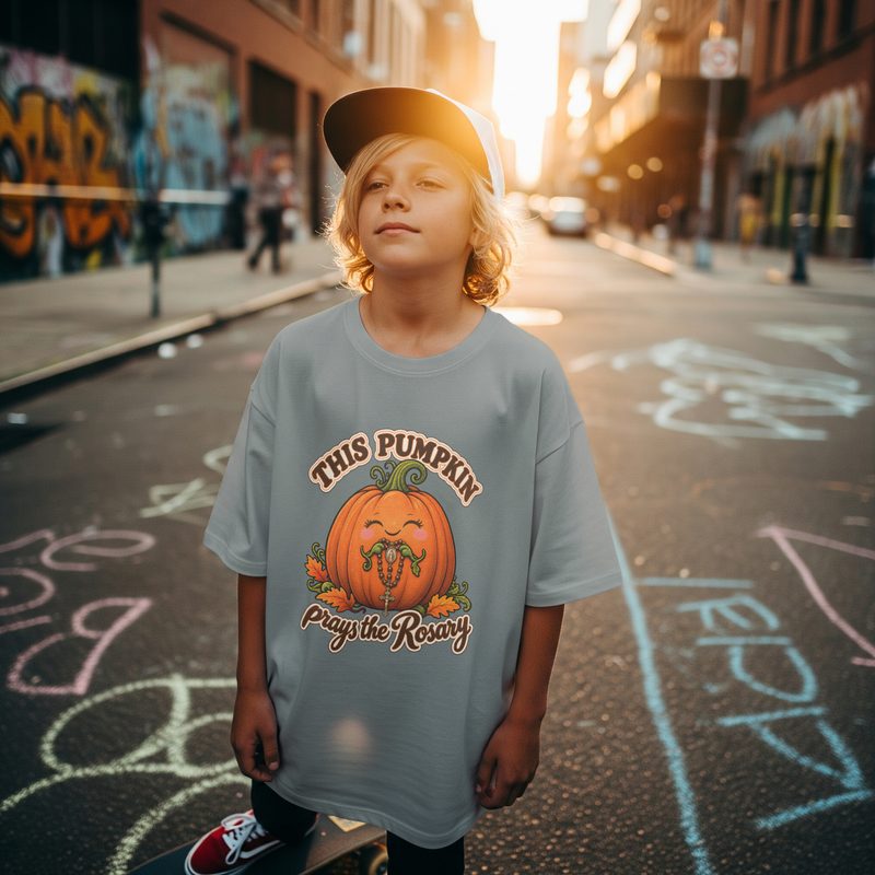 Model wearing the Kids Pumpkin Prays the Rosary Shirt with youth Catholic Halloween Outfit